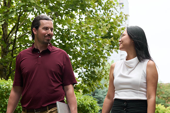 Two AZEK employees chat as they walk in a courtyard