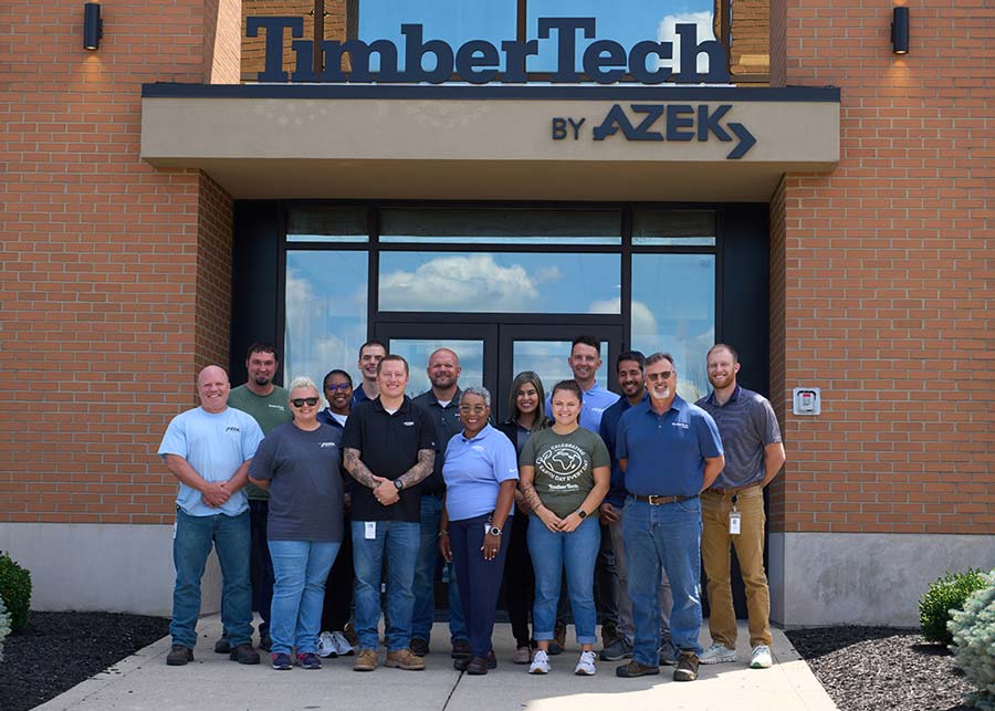A group of AZEK employees pose for a photo in front of a TimberTech office
